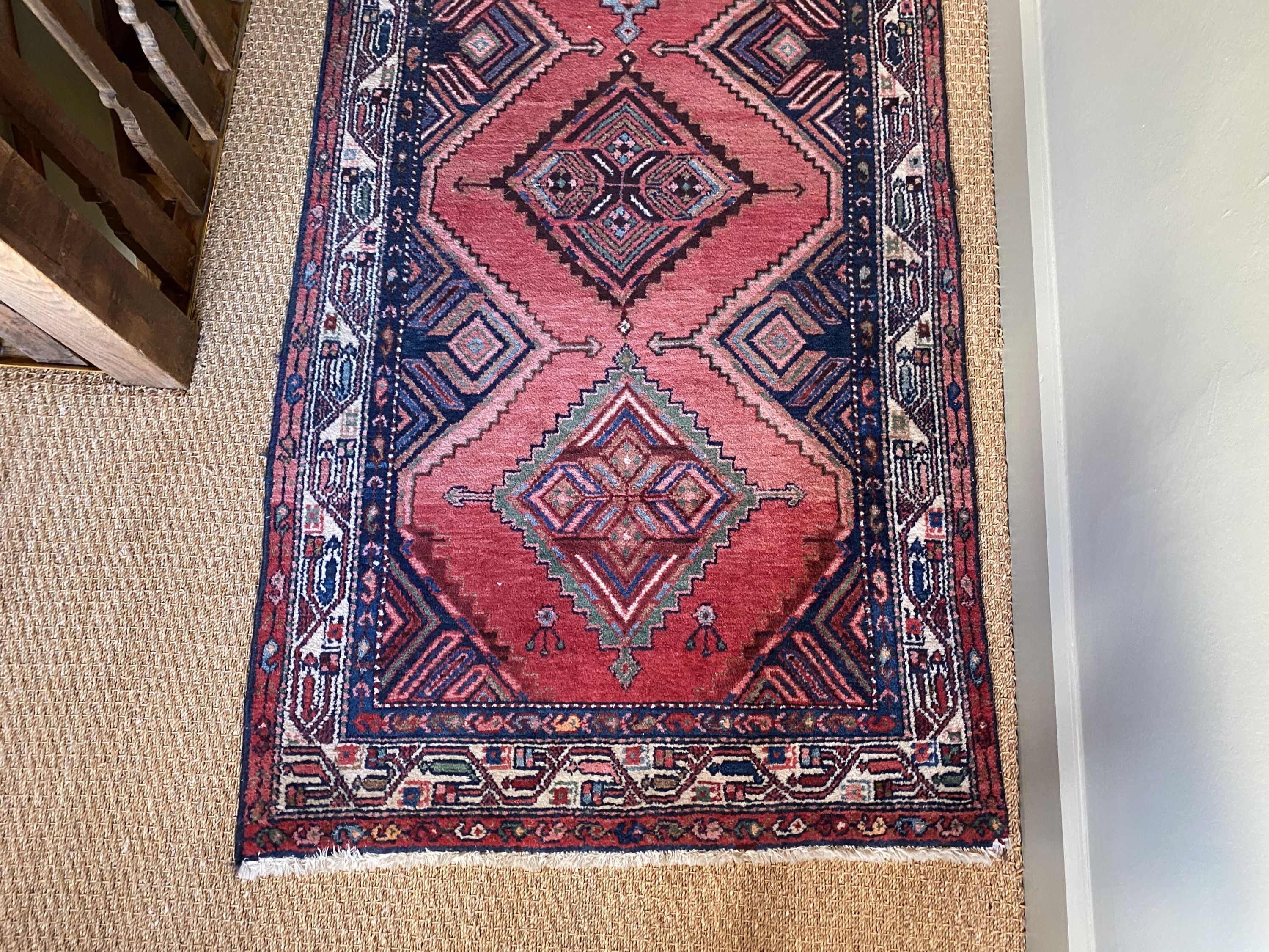 A Persian red ground runner, with five central lozenges, multi-bordered, 303 x 98cm